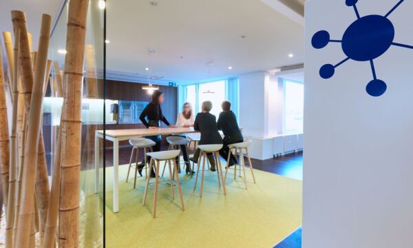 An eating area in which four ladies are sitting at a bar table on bar stools